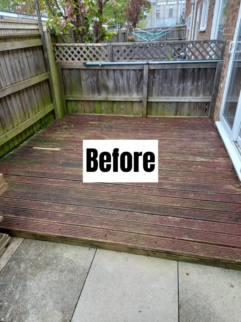 A weathered wooden deck with moss and discoloration, surrounded by a wooden fence and garden plants. The word "Before" is written on a white sign placed on the deck.